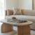 wooden coffee table, placed in a living room, beige coloured sofa, cushions, rug